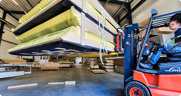 Heftruck met prefab elementen bij de werkplaats